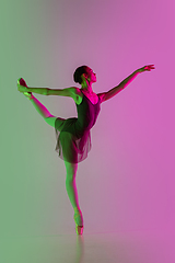 Image showing Young and graceful ballet dancer isolated on gradient pink-green studio background in neon light. Art in motion