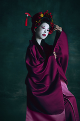 Image showing Young japanese woman as geisha on dark green background. Retro style, comparison of eras concept.