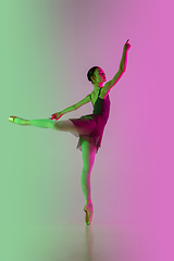 Image showing Young and graceful ballet dancer isolated on gradient pink-green studio background in neon light. Art in motion