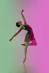 Image showing Young and graceful ballet dancer isolated on gradient pink-green studio background in neon light. Art in motion