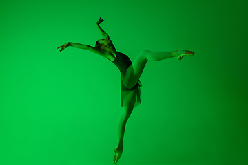 Image showing Young and graceful ballet dancer isolated on gradient green studio background in neon light. Art in motion