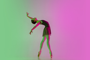 Image showing Young and graceful ballet dancer isolated on gradient pink-green studio background in neon light. Art in motion