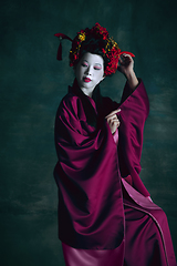 Image showing Young japanese woman as geisha on dark green background. Retro style, comparison of eras concept.