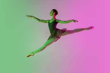 Image showing Young and graceful ballet dancer isolated on gradient pink-green studio background in neon light. Art in motion