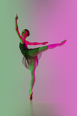 Image showing Young and graceful ballet dancer isolated on gradient pink-green studio background in neon light. Art in motion