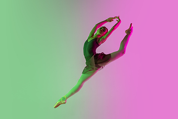 Image showing Young and graceful ballet dancer isolated on gradient pink-green studio background in neon light. Art in motion