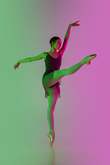 Image showing Young and graceful ballet dancer isolated on gradient pink-green studio background in neon light. Art in motion