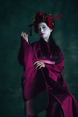 Image showing Young japanese woman as geisha on dark green background. Retro style, comparison of eras concept.