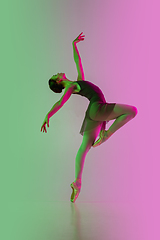 Image showing Young and graceful ballet dancer isolated on gradient pink-green studio background in neon light. Art in motion