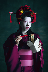 Image showing Young japanese woman as geisha on dark green background. Retro style, comparison of eras concept.