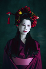 Image showing Young japanese woman as geisha on dark green background. Retro style, comparison of eras concept.