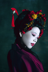 Image showing Young japanese woman as geisha on dark green background. Retro style, comparison of eras concept.