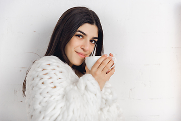 Image showing Portrait of beautiful woman isolated on white studio background. Comfort, warm in winter concept