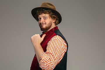 Image showing Happy smiling man dressed in traditional Austrian or Bavarian costume gesturing isolated on grey studio background