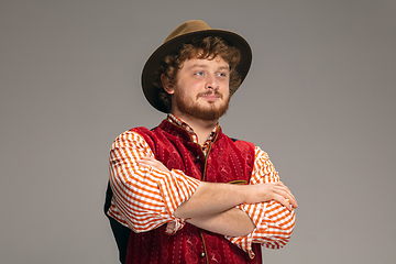 Image showing Happy smiling man dressed in traditional Austrian or Bavarian costume gesturing isolated on grey studio background