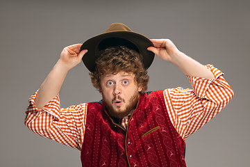 Image showing Happy smiling man dressed in traditional Austrian or Bavarian costume gesturing isolated on grey studio background