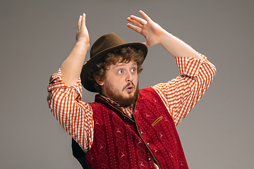 Image showing Happy smiling man dressed in traditional Austrian or Bavarian costume gesturing isolated on grey studio background