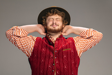 Image showing Happy smiling man dressed in traditional Austrian or Bavarian costume gesturing isolated on grey studio background