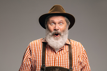 Image showing Happy senior man dressed in traditional Austrian or Bavarian costume gesturing isolated on grey studio background