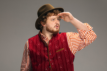 Image showing Happy smiling man dressed in traditional Austrian or Bavarian costume gesturing isolated on grey studio background