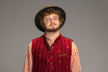 Image showing Happy smiling man dressed in traditional Austrian or Bavarian costume gesturing isolated on grey studio background