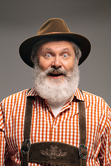 Image showing Happy senior man dressed in traditional Austrian or Bavarian costume gesturing isolated on grey studio background