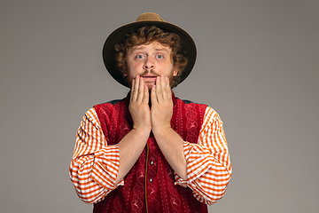 Image showing Happy smiling man dressed in traditional Austrian or Bavarian costume gesturing isolated on grey studio background