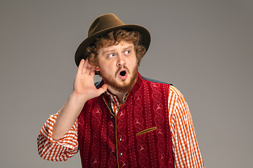 Image showing Happy smiling man dressed in traditional Austrian or Bavarian costume gesturing isolated on grey studio background