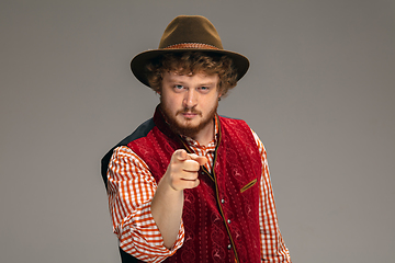 Image showing Happy smiling man dressed in traditional Austrian or Bavarian costume gesturing isolated on grey studio background