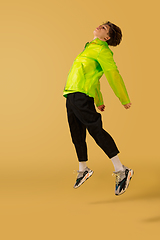 Image showing Old-school fashioned young man dancing isolated on yellow background