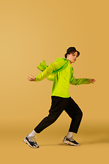 Image showing Old-school fashioned young man dancing isolated on yellow background