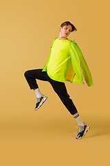 Image showing Old-school fashioned young man dancing isolated on yellow background