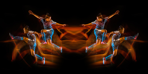 Image showing Football or soccer player on black studio background in mixed light with strobe light, mirror effect, reflection with fire flames