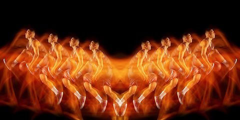 Image showing Young purposeful basketball player training in action isolated on black background with fire flames. Mirror, strobe light effect, reflection