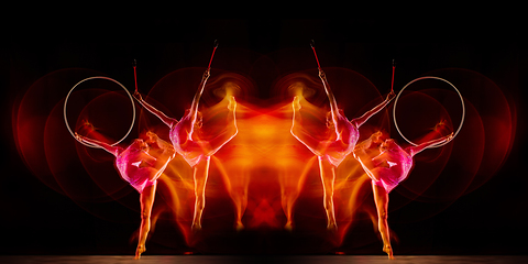 Image showing Little flexible girl isolated on black studio background. Fire flames, reflection, strobe light effect