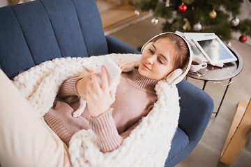 Image showing Young woman enjoying her domestic life. Home comfort, winter and holidays time