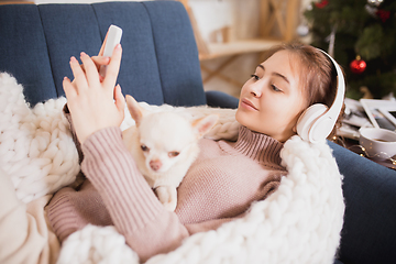 Image showing Young woman enjoying her domestic life. Home comfort, winter and holidays time