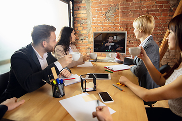 Image showing Young people talking, working during videoconference with colleagues at office or living room