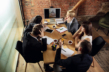 Image showing Young people talking, working during videoconference with colleagues at office or living room