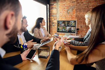 Image showing Young people talking, working during videoconference with colleagues at office or living room