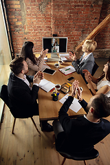 Image showing Young people talking, working during videoconference with colleagues at office or living room