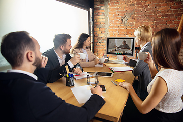 Image showing Young people talking, working during videoconference with colleagues at office or living room