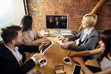 Image showing Young people talking, working during videoconference with colleagues at office or living room