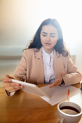 Image showing Young woman talking, working during videoconference with colleagues at home office