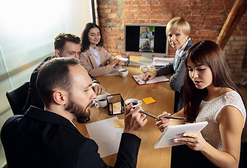 Image showing Young people talking, working during videoconference with colleagues at office or living room