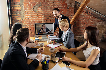 Image showing Young people talking, working during videoconference with colleagues at office or living room