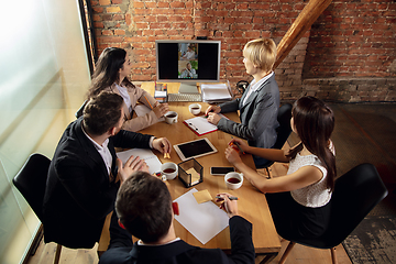 Image showing Young people talking, working during videoconference with colleagues at office or living room