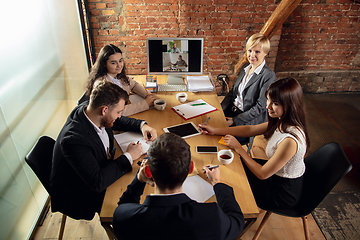 Image showing Young people talking, working during videoconference with colleagues at office or living room