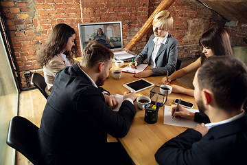 Image showing Young people talking, working during videoconference with colleagues at office or living room