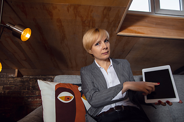 Image showing Young woman talking, working during videoconference with colleagues at home office